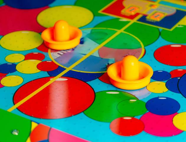Close Up of a Colorful Board Game The image shows a close-up view of a colorful board game with various game pieces, cards, and dice spread out on the board. The vibrant colors and intricate design of the game elements are prominently displayed.